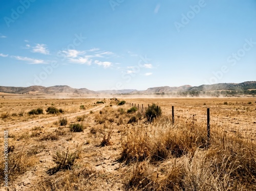 Dry open prairie landscape with dirt road and fence for nature background and countryside wallpaper