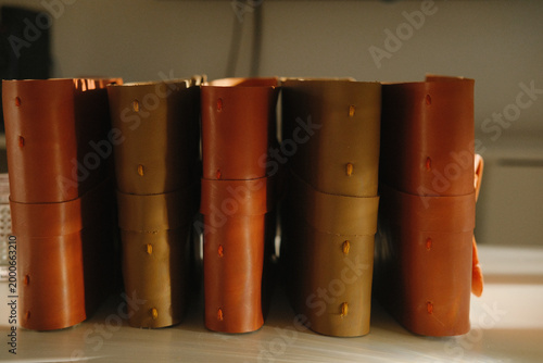 Books with colorful spines lined up on a shelf in a library, closeup of row of volumes ready for reading, study or research under warm office light