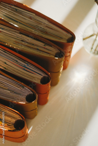 Notebook stack in warm light, aged leather covers and textured pages, closeup on bindings, study setup with journals and writing mood, creative workspace ambience