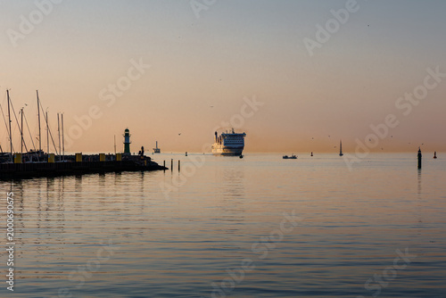 Boot auf der Ostsee vor Warnemünde bei Sonnenuntergang mit ruhiger Wasseroberfläche