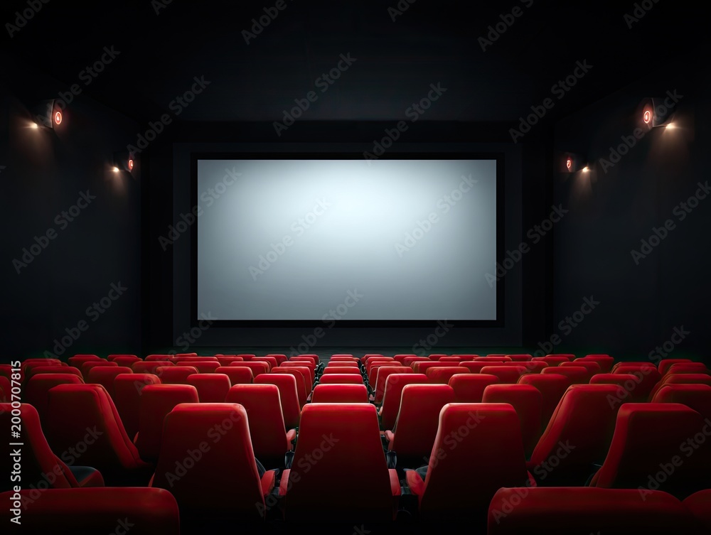 Fototapeta premium Empty cinema auditorium with rows of red seating facing a large, illuminated screen