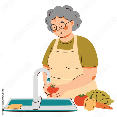 Grandmother washing red tomato under kitchen tap. Elderly woman in apron preparing fresh vegetables