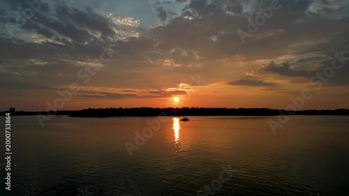 Beautiful sunset at Hietaniemi Beach in Helsinki, Finland. Warm golden light reflects over the Baltic Sea, creating a calm and peaceful evening atmosphere along the coastline.