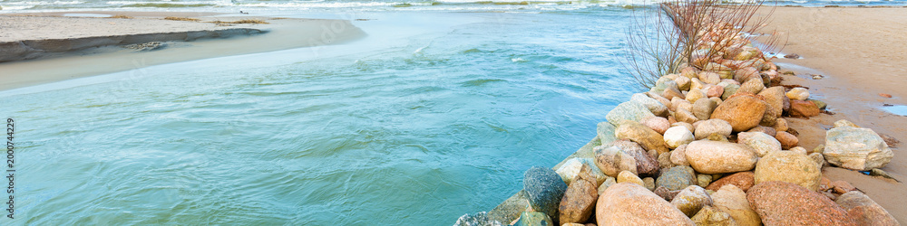 Obraz premium Delta in the daytime. Rocky bank of river. The river flows into the sea