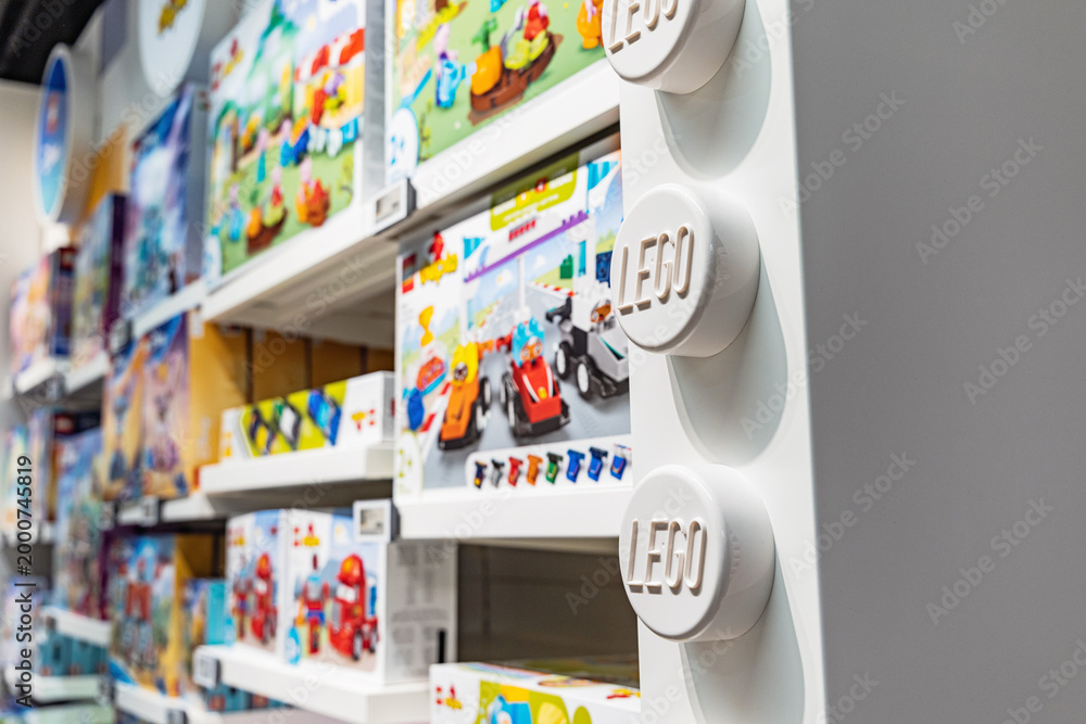 Fototapeta premium 19 October 2025, Belgrade, Serbia: LEGO toy store aisle with shelves displaying various colorful box sets and large branded wall elements