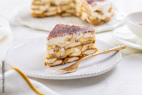 Delicious homemade tiramisu dessert with banana slices and cocoa powder