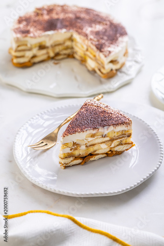 Delicious homemade tiramisu dessert with banana slices and cocoa powder