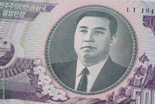 Close-up macro view of a 5000 North Korean Won banknote featuring the portrait of Kim Il-sung. DPRK paper currency details. 