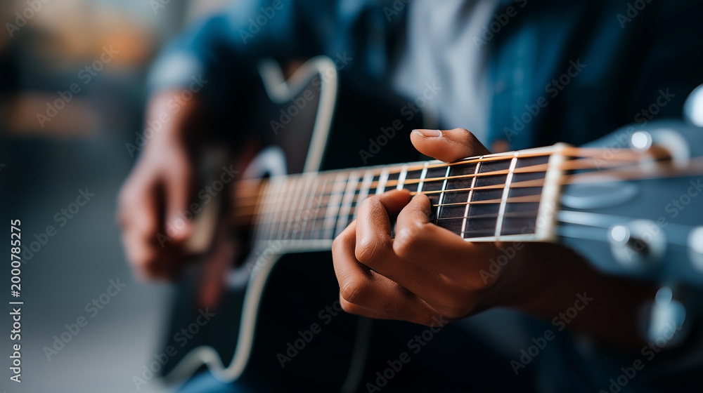 Obraz premium Close-up of hands holding an acoustic guitar with fingers on strings, music hobby concept, guitarist lifestyle, home music practice, defocused background, with copy space