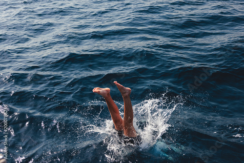 Canvastavla Person diving into deep blue ocean water creating splash