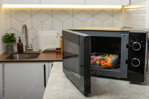 Tableau sur toile Modern black microwave on the kitchen countertop