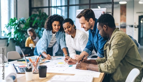 Diverse group of professionals collaborating on a project in a modern office environment.