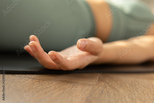 Foto Close up woman hand palm open resting peacefully yoga mat floor green sportswear