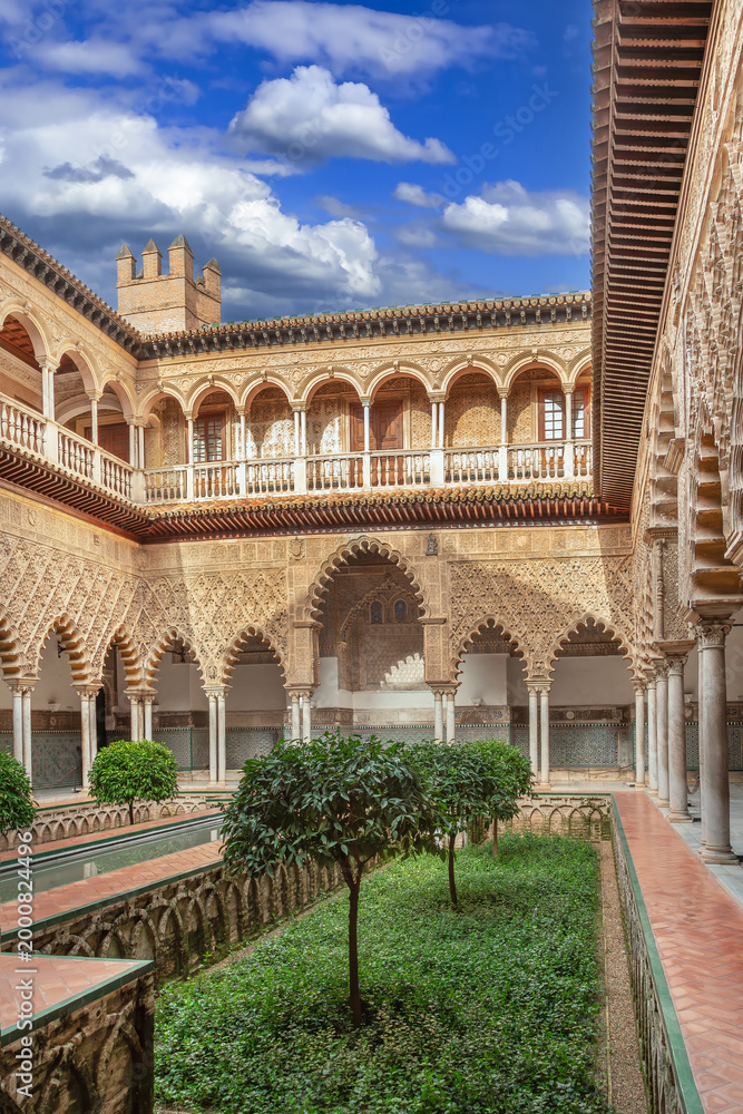 Fototapeta premium Main courtyard Patio de las Doncellas in Alcazar of Seville Spain. Mudejar architecture with arches and stone columns