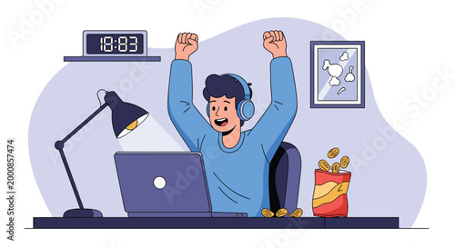 Happy young man wearing headphones celebrates a victory while sitting at his desk with a laptop, lamp, clock, and snacks in a home office setting.