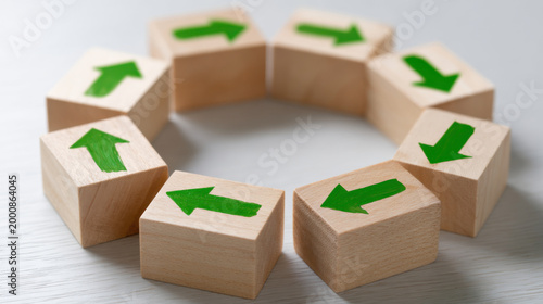 Wooden block circle with green arrow symbols on light surface, abstract concept of cycle, direction, teamwork, and process flow