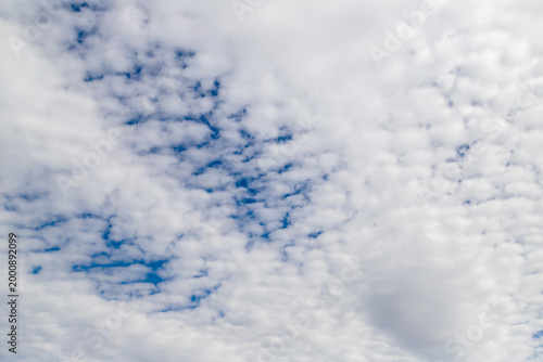 Altocumulus cloud pattern across blue sky with textured white clouds and soft...