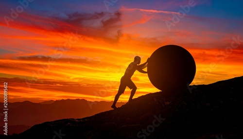 Silhouette Pushing Boulder Uphill Showcasing Perseverance, Struggle, and Motivational Conceptual Photography Design