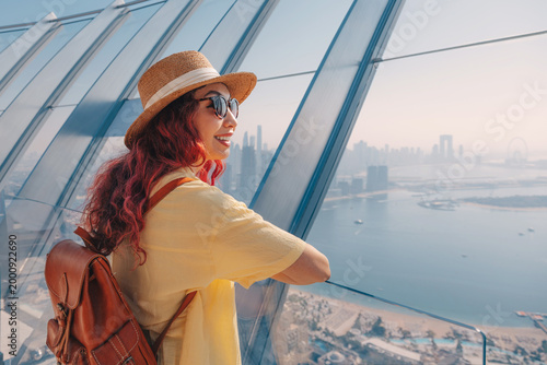 Quadro em tela Young woman tourist on a viewpoint admiring Palm Jumeirah and Dubai skyline, emb