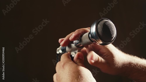Retro microphone on studio or stage, macro of check sound, hand touch microphone. 