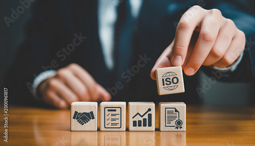 Person placing iso certification cube onto a sequence of business process blocks