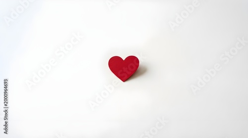 A simple red heart placed on a clean white background, representing pure love and minimalism.