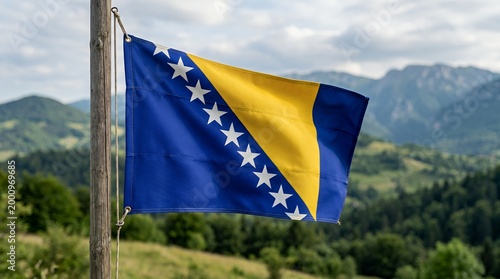 Bosnia and Herzegovina flag waving in mountainous landscape