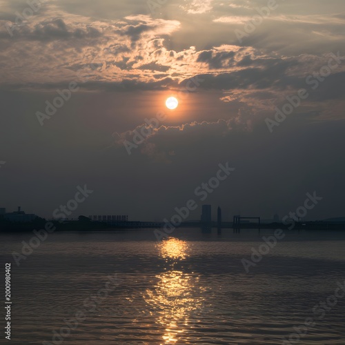 Sunrise over silhouette of a lone tree in a dark landscape