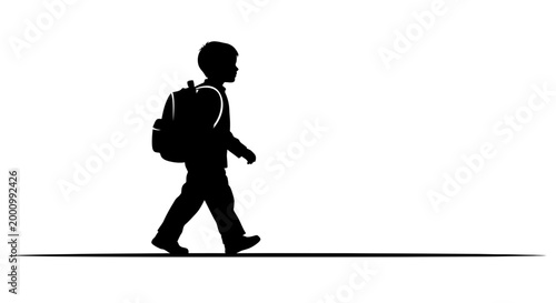 Silhouette of a young schoolboy walking with a backpack.