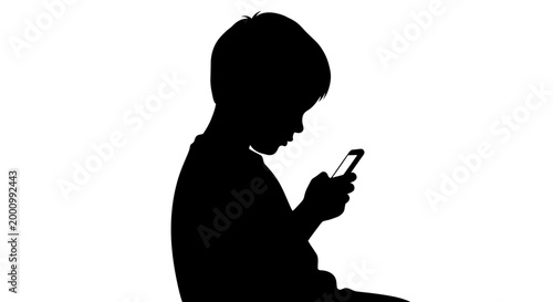 Silhouette of a young boy using a smartphone.