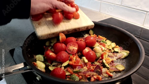 Stockholm, Sweden A cook fries vegetables for a tomato pasta sauce on an induction stovetop. 