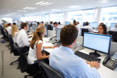 Busy open-plan office with employees working at computers and desks