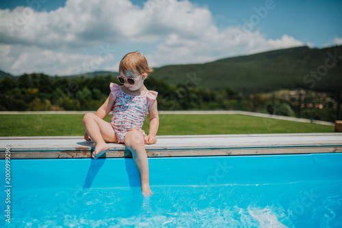 Quadro su tela Little girl enjoying summer by the pool