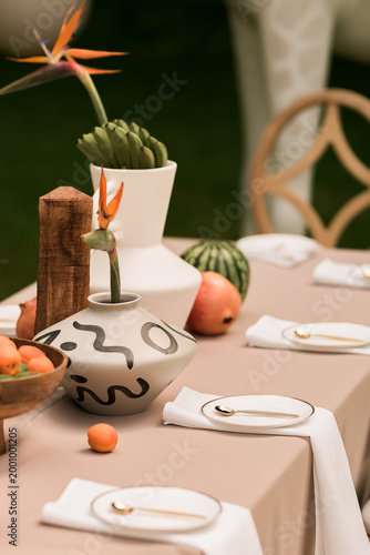 Fotografía Elegant outdoor tablescape with sculptural vases, tropical flowers and fresh fru