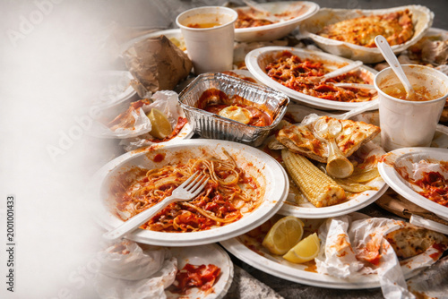 Dirty disposable plates with leftover food. Space for text.