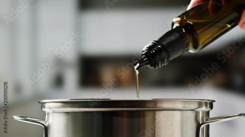 Pouring olive linen oil sunflower in different dishes close-up. Using in cooking for frying foods or as a salad dressing omega 3. Olive oil is popular supplement for meals and salads. 