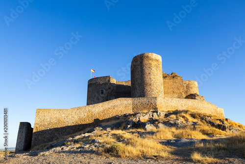 Consuegra castle landmark with Spanish flag flying under clear sky
