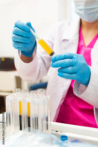 Blood plasma in tubes. Chemistry laboratory. Regenerative medicine. Non-surgical procedures. Lab technician holding test tube of blood sample after being centrifuged. Blood taken from patient