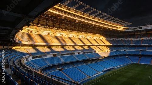 Showcasing multi-tiered seating and roof trusses glowing at stadium bowl, with blue seats
