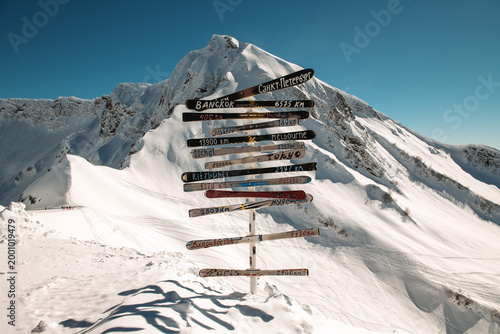 Φωτογραφία Signposts Mark Distances to Various Cities With a Snowy Mountain Backdrop in Bri