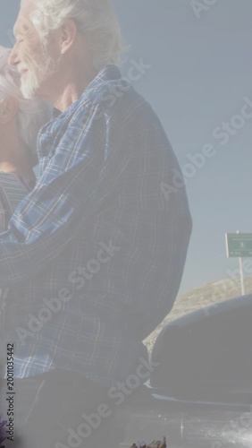 Vertical video: Senior couple leaning, animated flower appearing on trunk, evoking travel memory