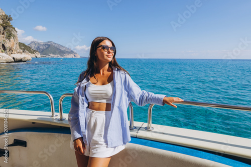 Woman enjoying a boat trip along the scenic coastline of Gulf of Orosei, Sardinia, exploring natural caves