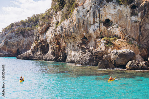 Foto Two people kayaking in turquoise water near limestone cliffs and sea caves at Gr