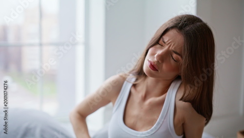 Foto Suffering woman feeling belly ache menstrual spasm waking up in morning closeup