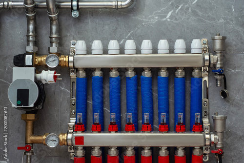 Fotografía Hydronic heating collector with red and blue insulated pipes and thermal actuators