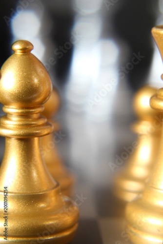 Macro phot golden chess pieces on the board concept strategy business vertical orientation