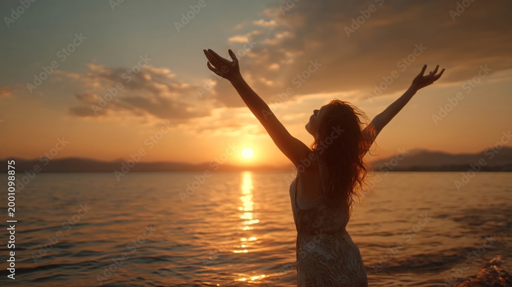 Fototapeta premium Sunset Serenity: A woman stands with open arms, embracing the golden hues of a setting sun over tranquil waters, a moment of peace and freedom.