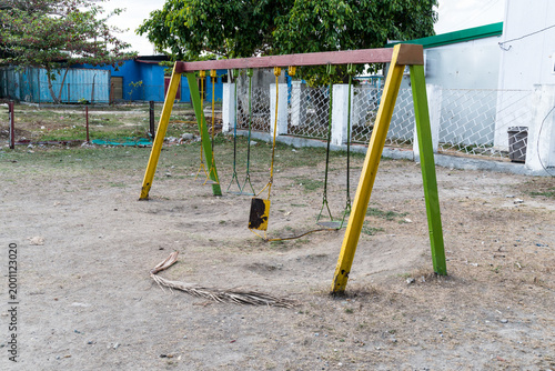 Cuba, Cienfuegos.  A forlorn looking swing set in children's playground.