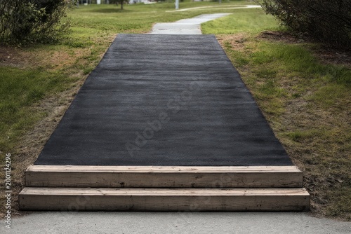 Dark path ascends via wooden steps through lush green parkland