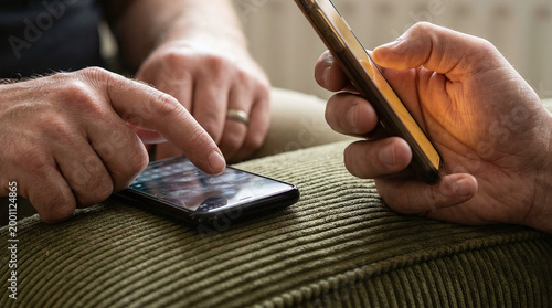 Phubbing and digital disconnection: Macro Detail of Hands Scrolling Phones on Couch